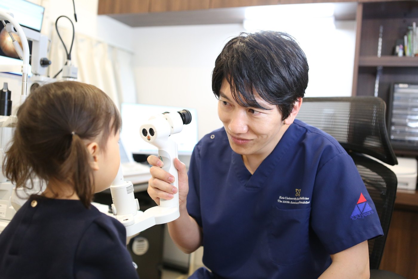 診察室で子どもの目を診る上月直之